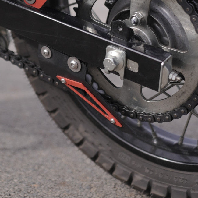 MotoCare red chain sprocket guard installed on Hero XPulse 210 protecting chain and sprocket system